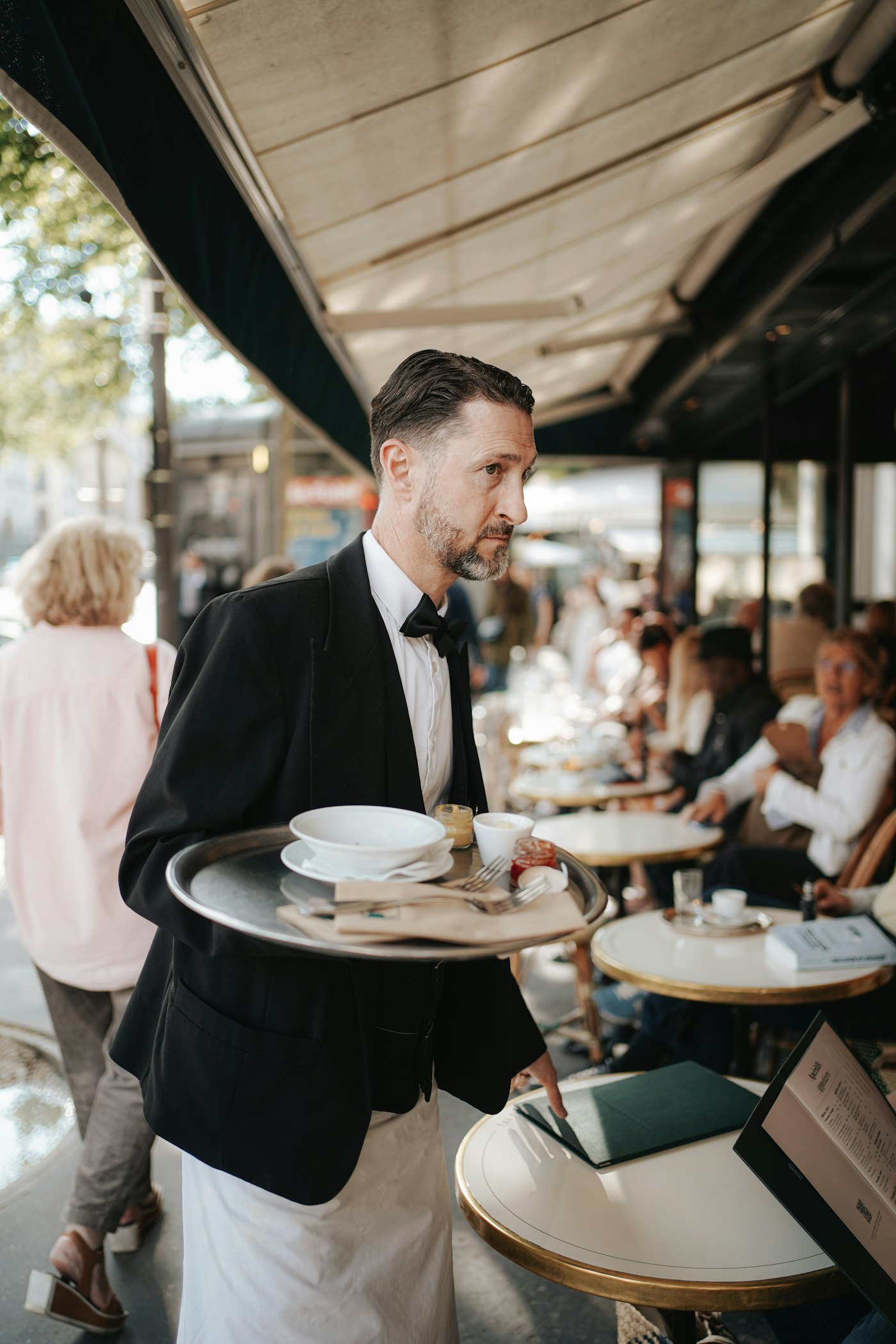 Ein Kellner serviert auf einer Caféterrasse